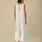 back view ofmodel wearing white wide leg jumpsuit with 'copacabana brasil' graphic on the front