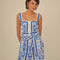 model wearing blue and white title print romper with button front, smocked back, and tie waist