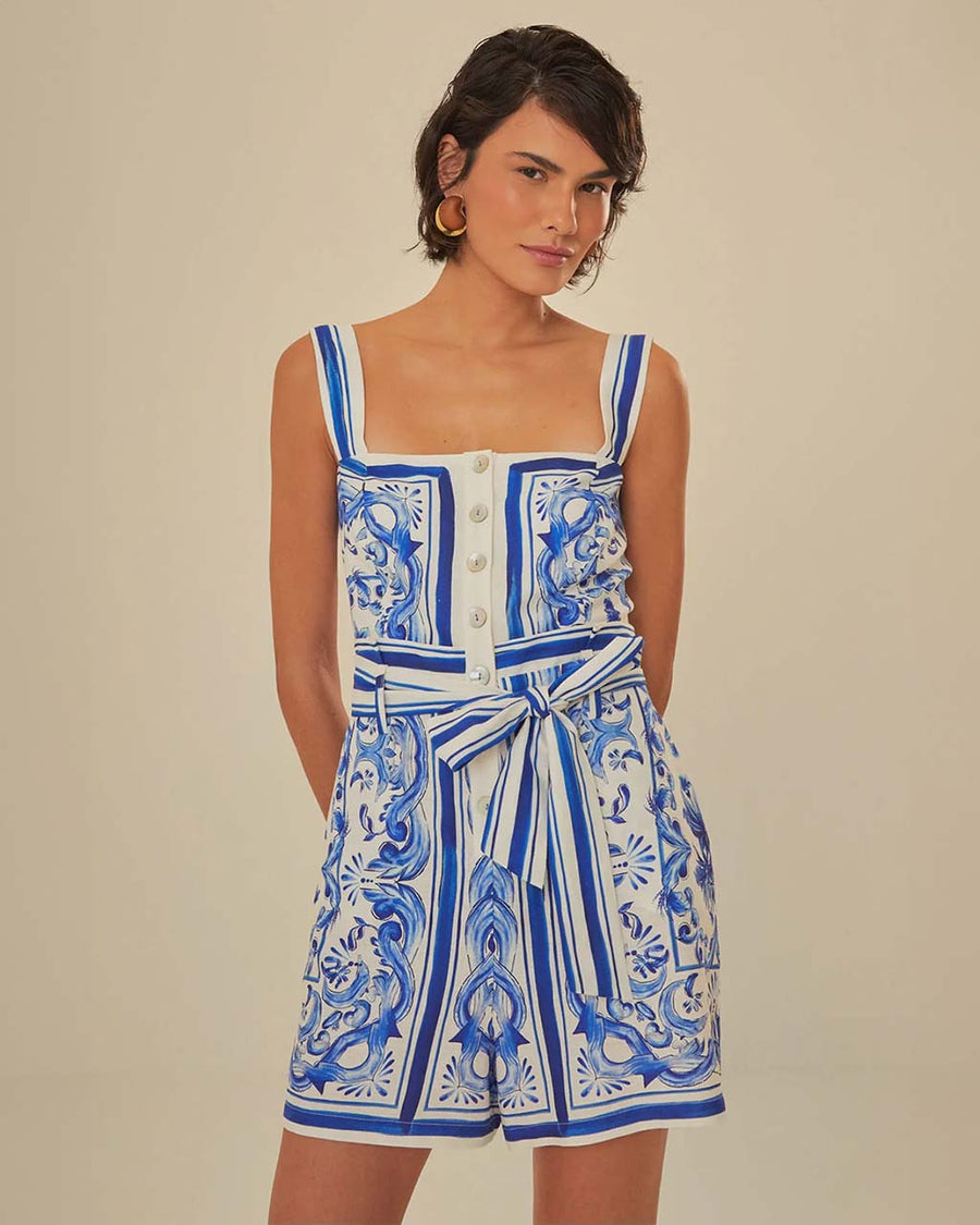 model wearing blue and white title print romper with button front, smocked back, and tie waist