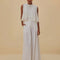 model wearing white wide leg linen pants with gold belt detail