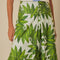 up close of model wearing white maxi skirt with button front detail and palm leaf detail