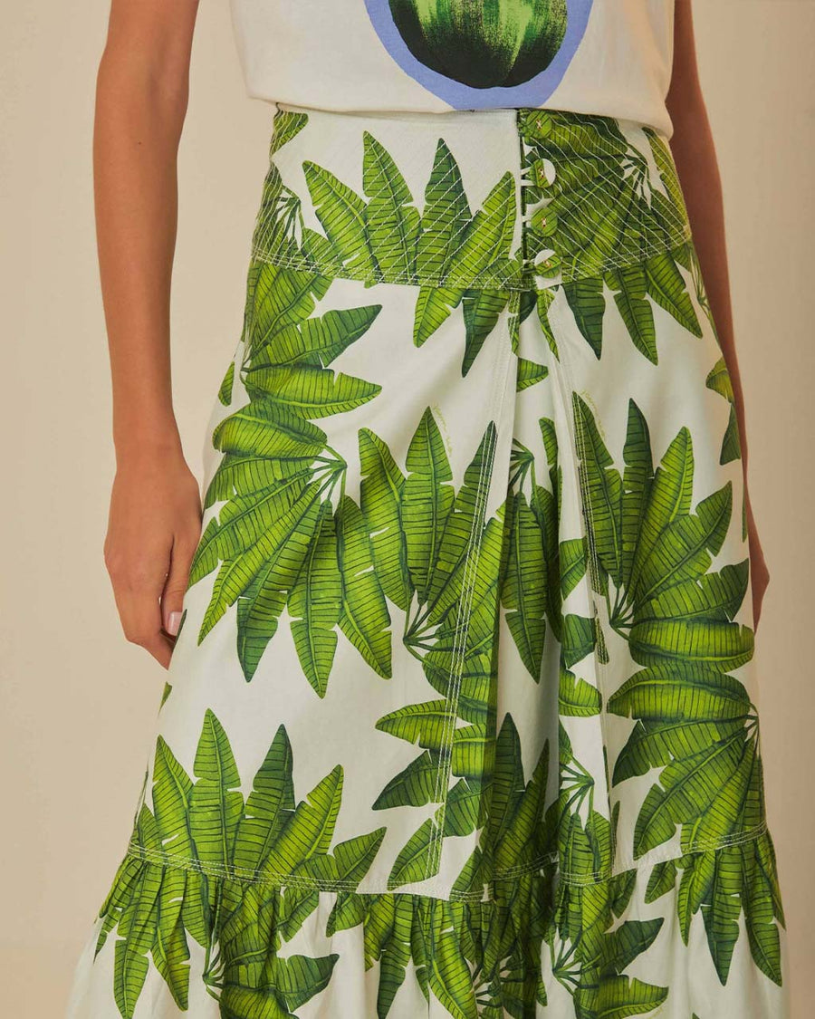 up close of model wearing white maxi skirt with button front detail and palm leaf detail