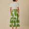 back view of model wearing white maxi skirt with button front detail and palm leaf detail