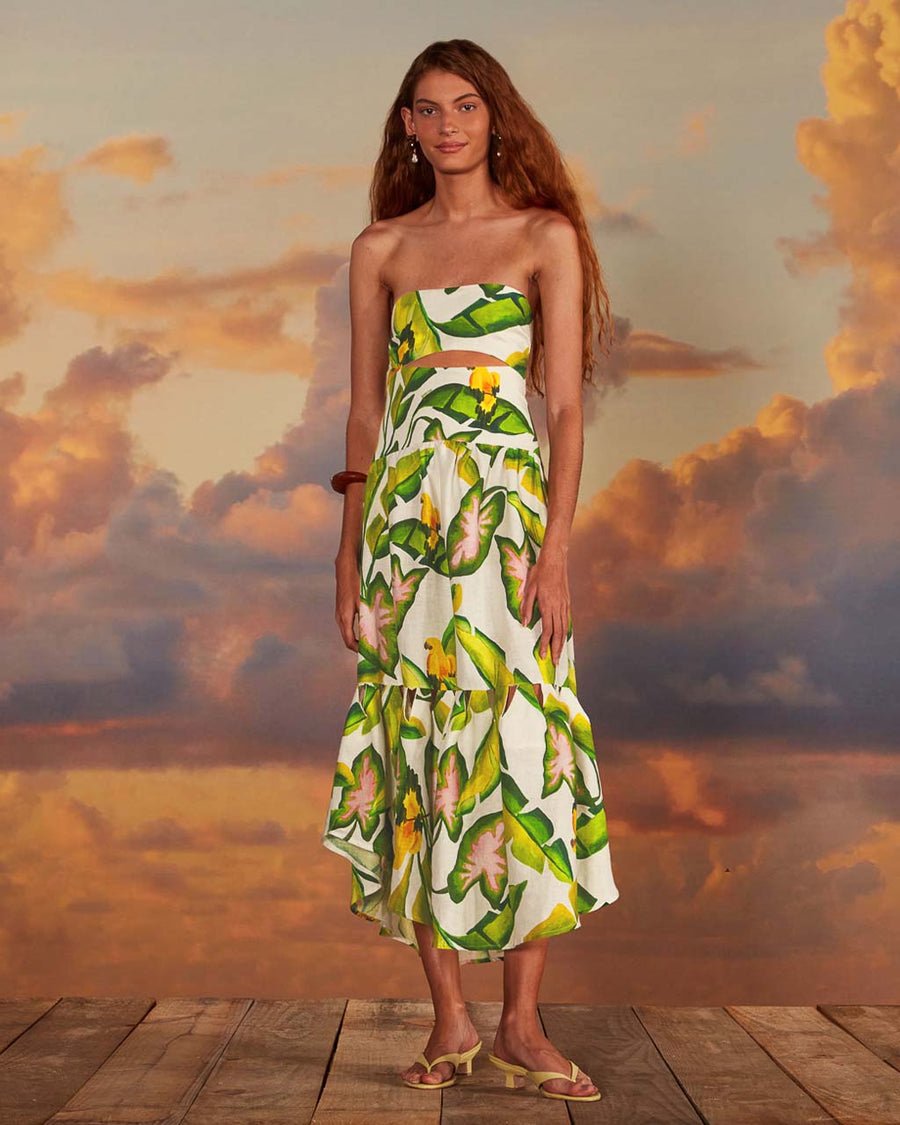 model wearing white midi dress with cut out on the bodice and vibrant palm leaf print