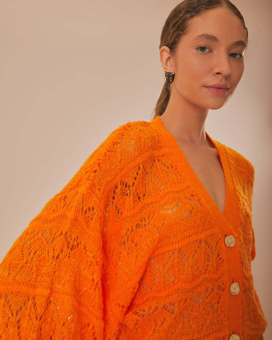 model wearing orange open knit textured cardigan