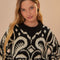 up close of model wearing black and white ikat print sweater