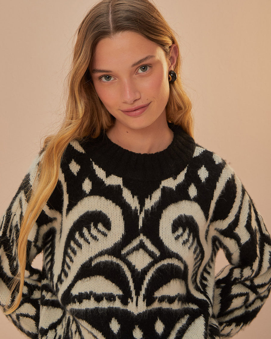 up close of model wearing black and white ikat print sweater