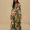 model wearing pink banana leaves maxi dress with deep v neckline, long sleeves and pleated detail