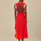 back view of model wearing red midi dress with white flowers on the sides and beaded cinched tie bodice