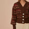 model wearing brown cropped cardigan with puff sleeves and red and cream woven stripe design