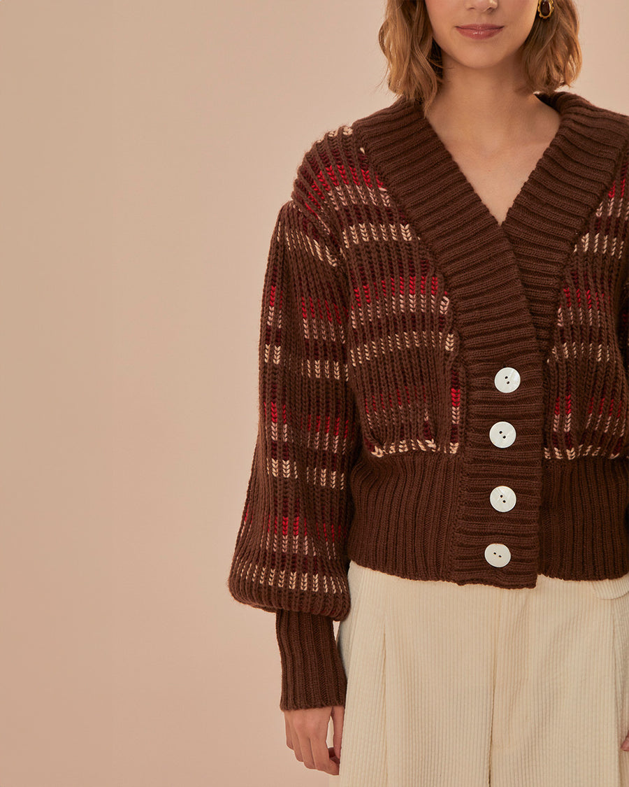 model wearing brown cropped cardigan with puff sleeves and red and cream woven stripe design