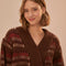 up close of model wearing brown cropped cardigan with puff sleeves and red and cream woven stripe design