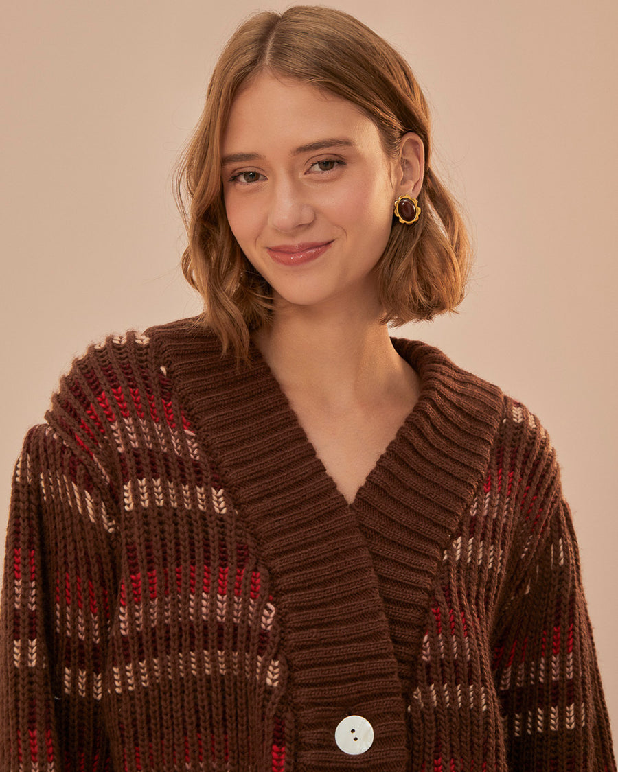 up close of model wearing brown cropped cardigan with puff sleeves and red and cream woven stripe design