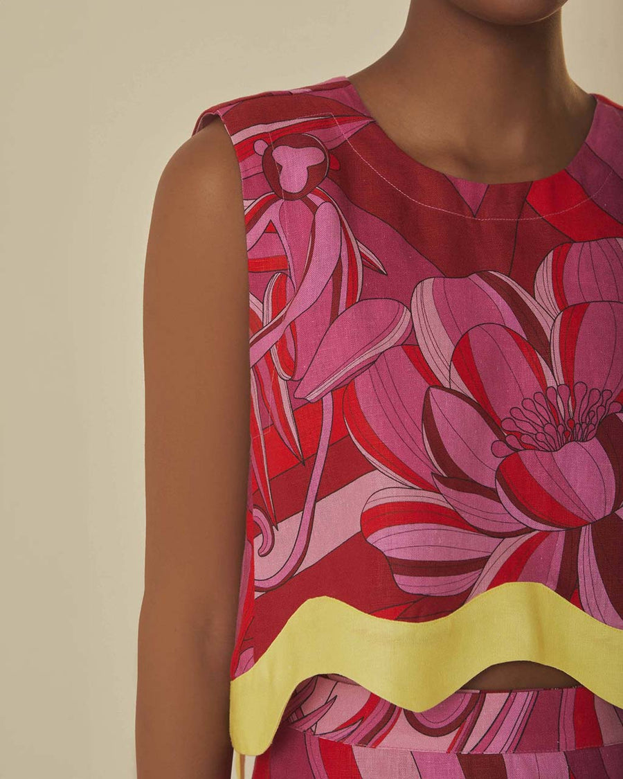 up close of model wearing pink and red abstract floral tank with wavy yellow trim