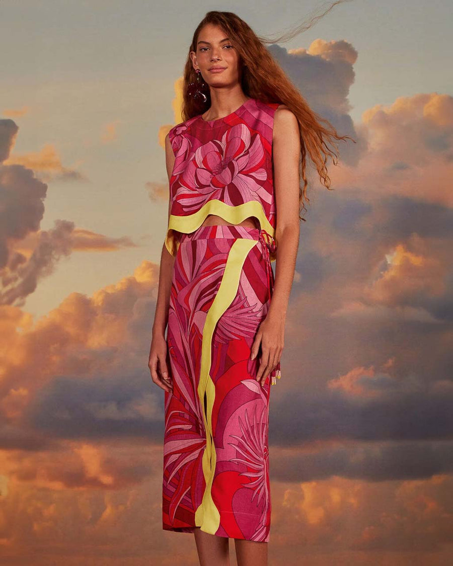 model wearing pink and red abstract floral print with yellow wavy trim and beaded tie waist and matching tank