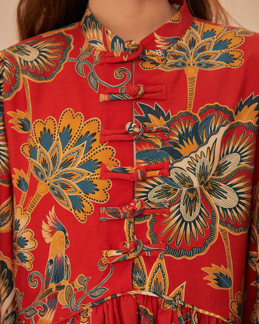 up close of model wearing red long sleeve mini dress with all over floral print and toggle button front detail