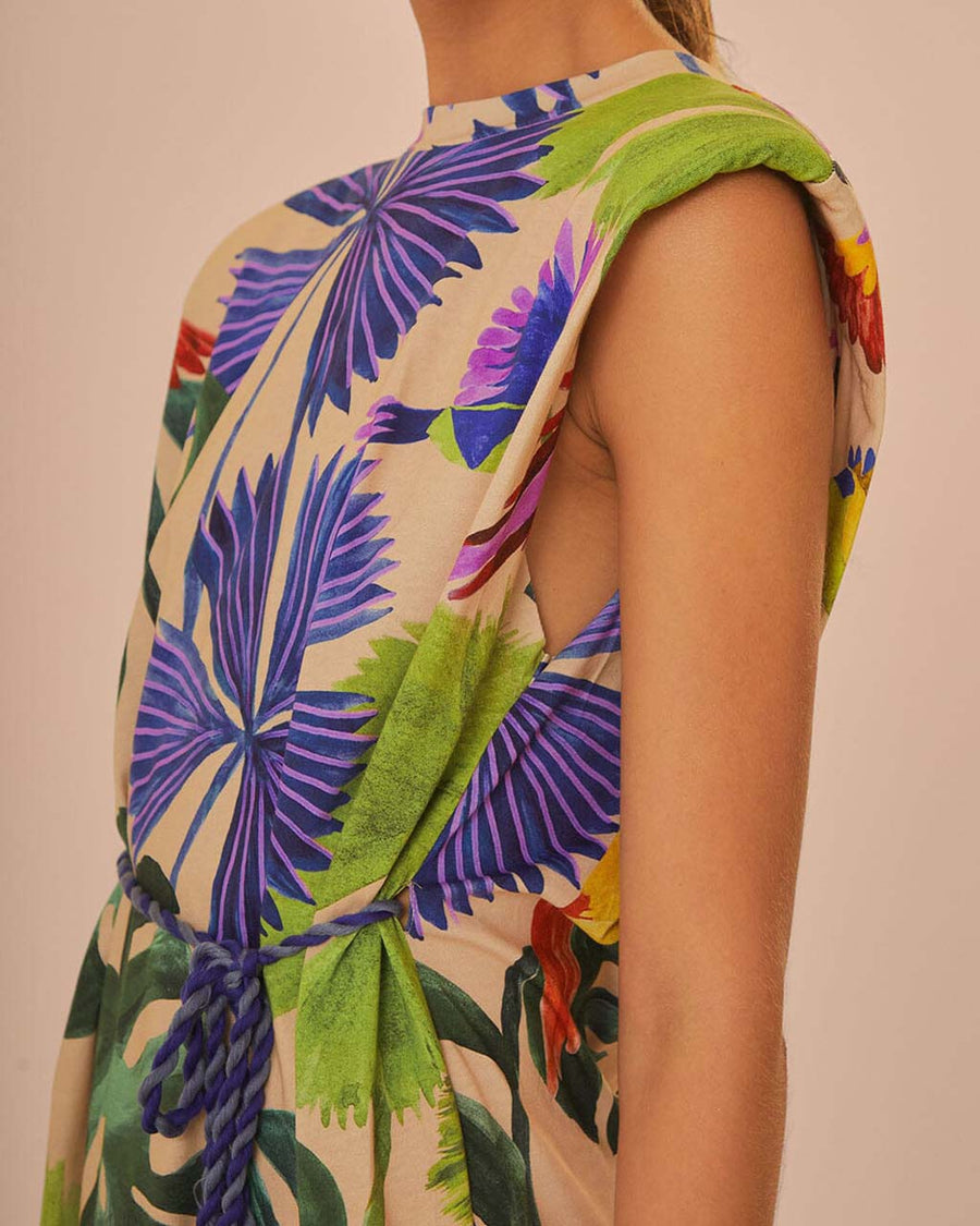 sideview of model wearing sand t-shirt dress with colorful tropical print and tie waist