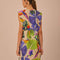 back view of model wearing sand t-shirt dress with colorful tropical print and tie waist