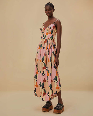 model wearing pink midi dress with curved hem, corset bodice, and colorful abstract print