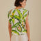 back view of model wearing off white square shoulder top with green tropical leaf print