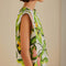 side view of model wearing off white square shoulder top with green tropical leaf print