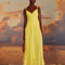 model wearing yellow dress with criss cross bodice and knots in the straps