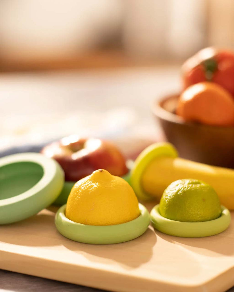 set of 5 various green and yellow green food huggers being used with various fruits and veggies