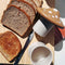 tan mushroom shaped utter storage container on a board with sliced bread