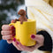 model holding brown dog shaped tea infuser in a cup