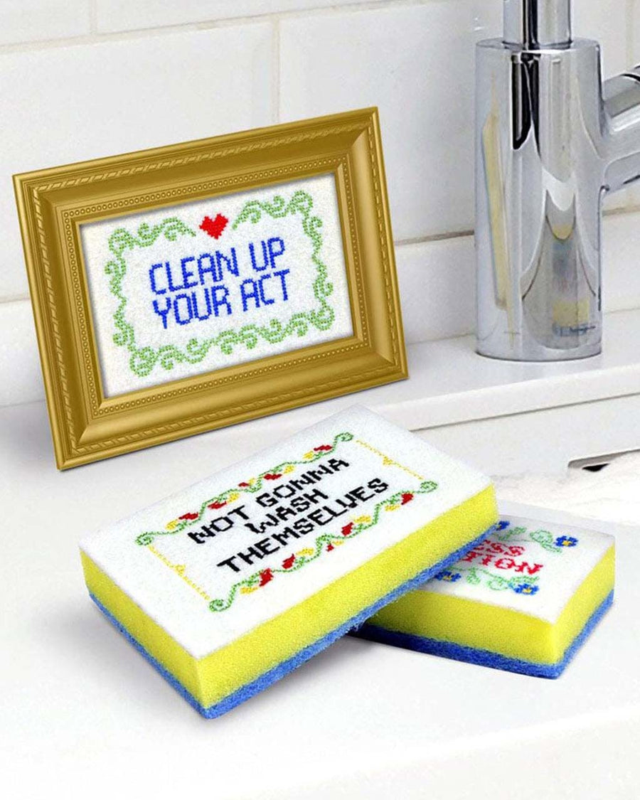 set of 4 embroidered like sponge with sassy sayings on them on a sink