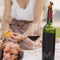 model picnicking with brown dog wine bottle stopper and dog sleeping next to her