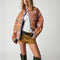 model wearing colorful floral quilted jacket with periwinkle piping and trim