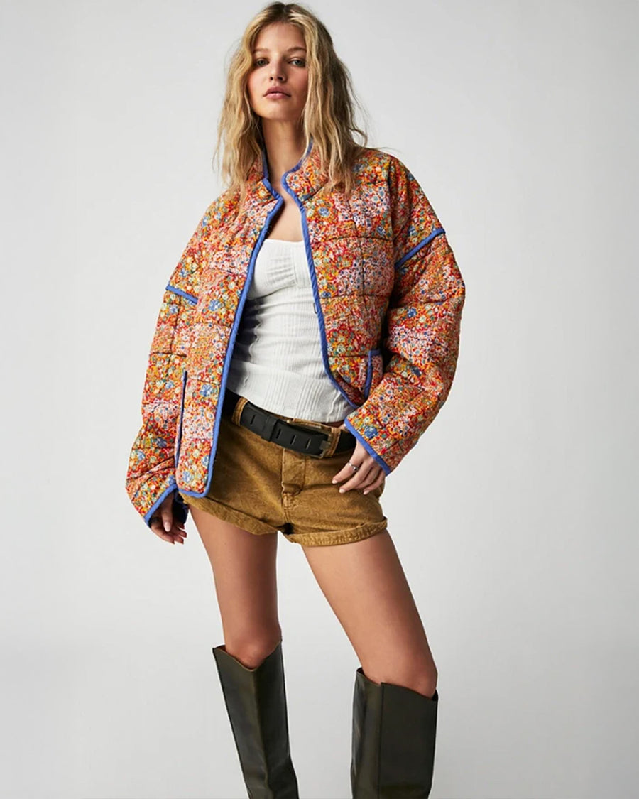 model wearing colorful floral quilted jacket with periwinkle piping and trim