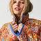 up close of model wearing colorful floral quilted jacket with periwinkle piping and trim