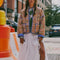 model wearing colorful floral quilted jacket with periwinkle piping and trim and white flowy skirt