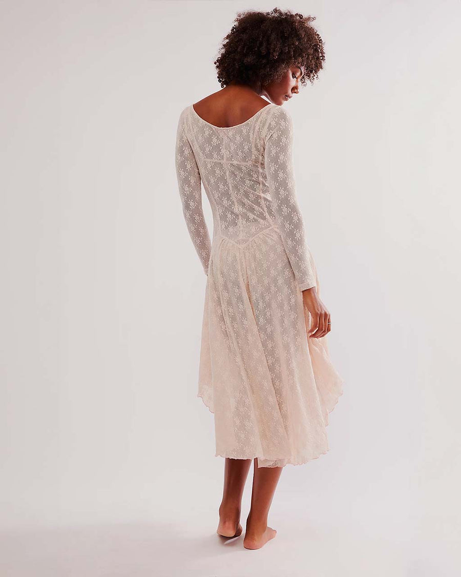 back view of model wearing pretty cream slip lace midi dress with long sleeves and completely sheer lace