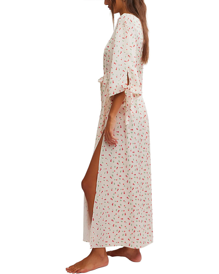 side view of model wearing cream maxi robe with elastic tie waist and red ditsy floral print