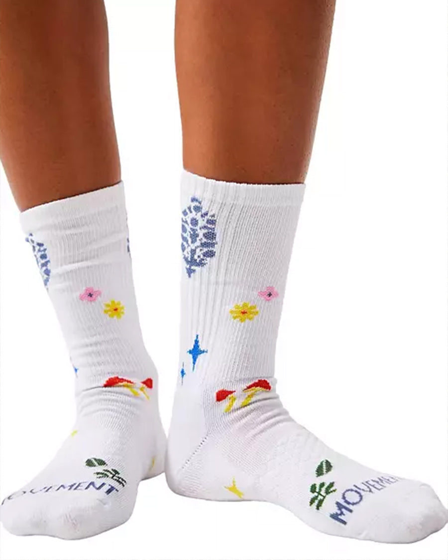 model wearing white long crew socks with colorful leaves, floral and mushroom print