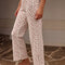 model wearing cream lounge  pants with red floral print and slits on the legs