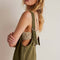 side view of model wearing moss green jumpsuit with adjustable straps and patch front pockets