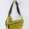 hanging green crescent shaped sling bag with black adjustable strap and small pouch attached