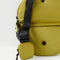 interior of green crescent shaped sling bag with black adjustable strap and small pouch attached