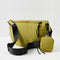 back view of green crescent shaped sling bag with black adjustable strap and small pouch attached