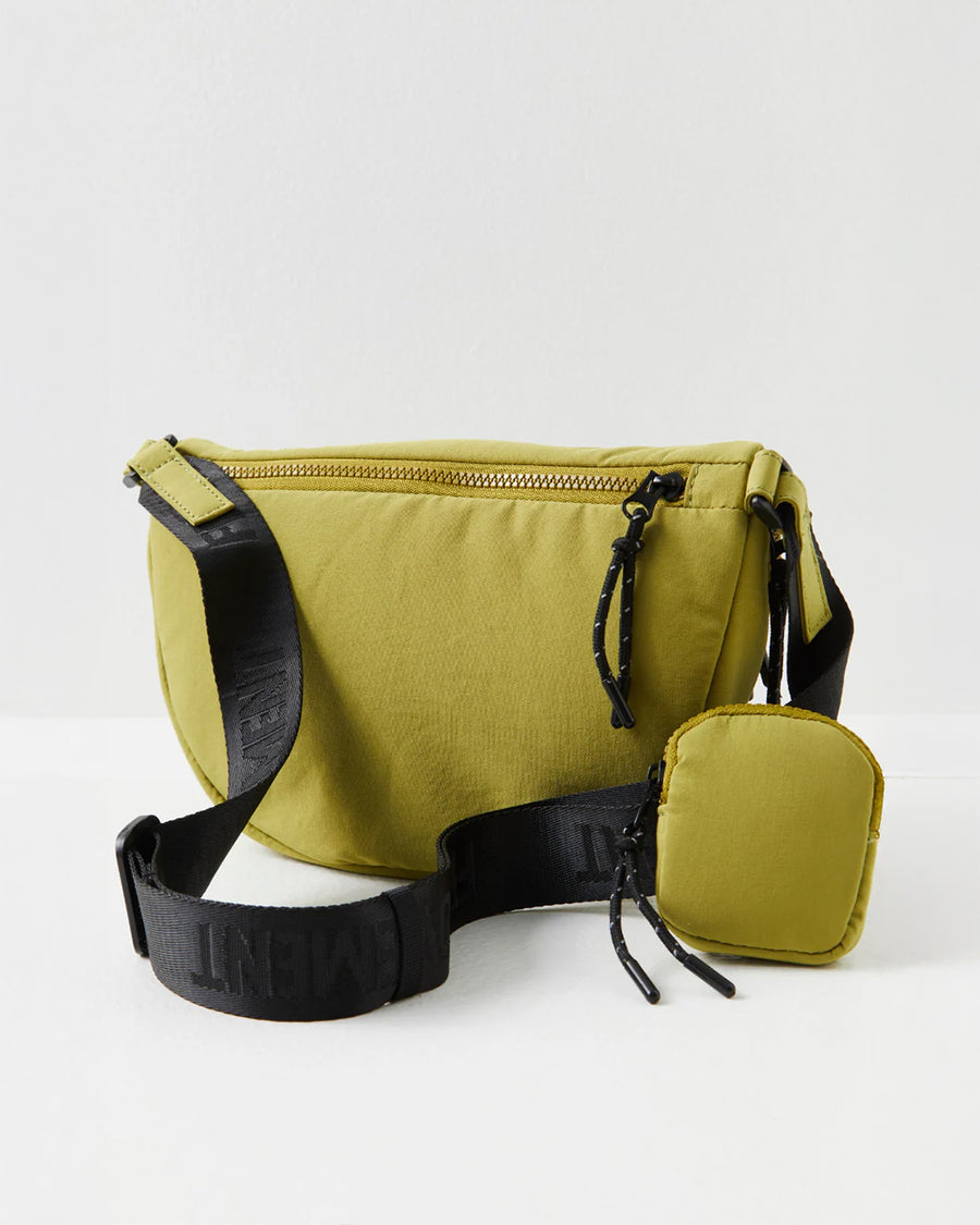 back view of green crescent shaped sling bag with black adjustable strap and small pouch attached