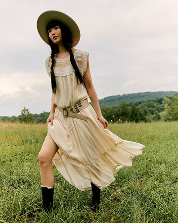 model wearing cream shapeless maxi dress with intricate tank top sleeves, tiered skirt with various lace detail 