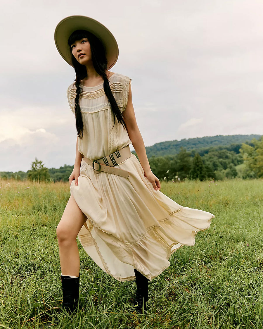 model wearing cream shapeless maxi dress with intricate tank top sleeves, tiered skirt with various lace detail 