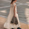 back view of model wearing cream shapeless maxi dress with intricate tank top sleeves, tiered skirt with various lace detail 