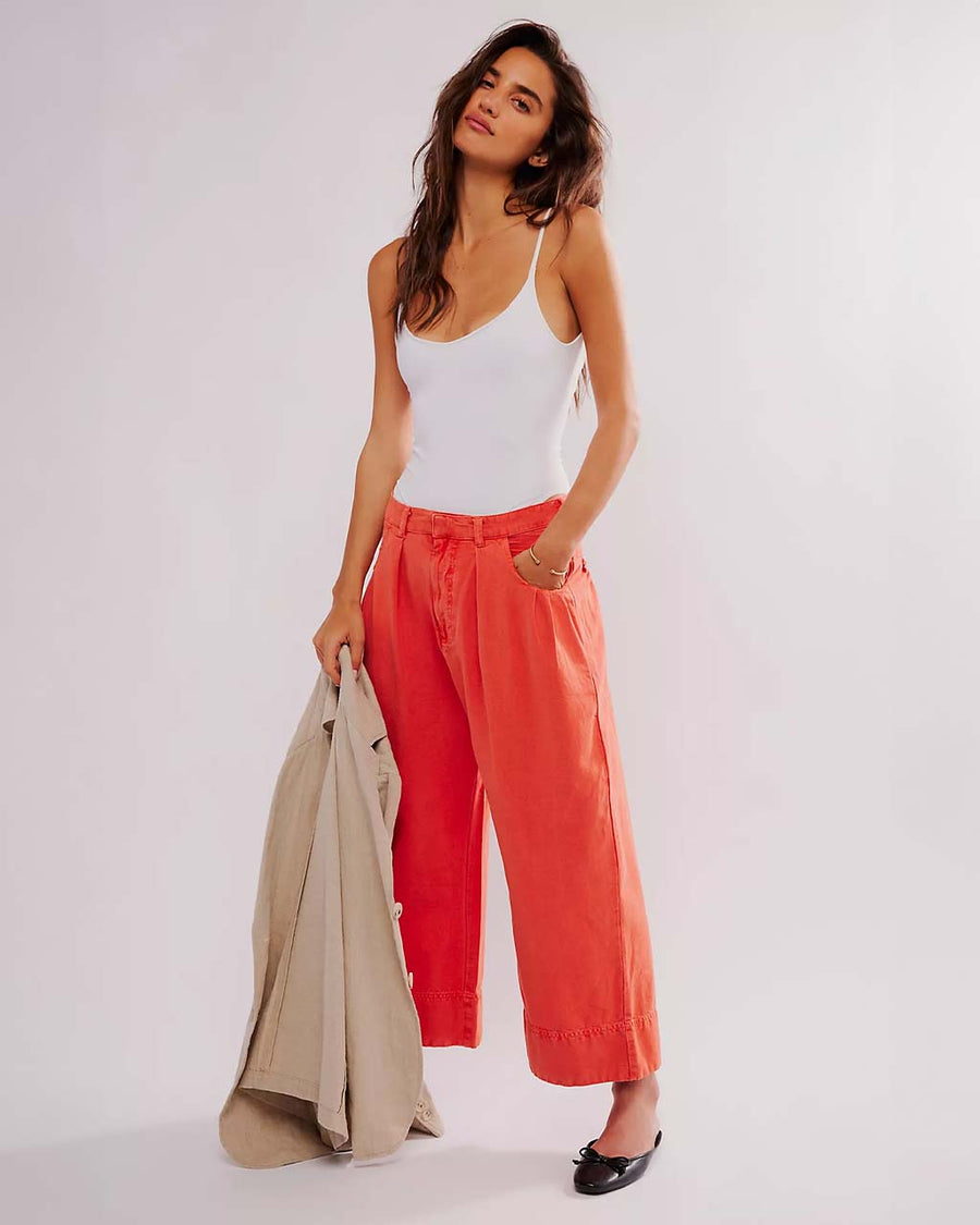 model wearing bright red pants with relaxed fit and waist detail