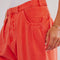 up close of model wearing bright red pants with relaxed fit and waist detail