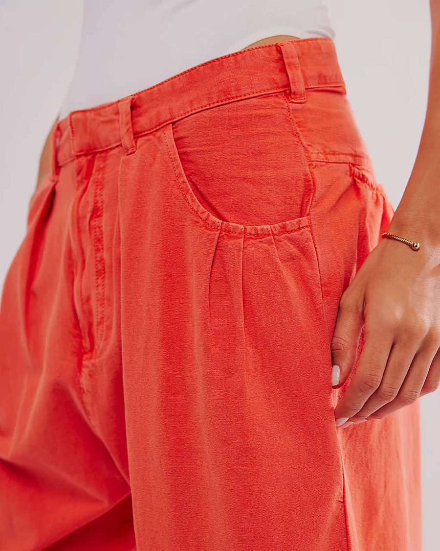 up close of model wearing bright red pants with relaxed fit and waist detail